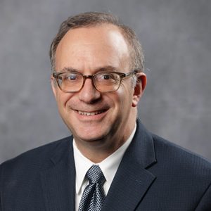 Headshot of man in a blue blazer